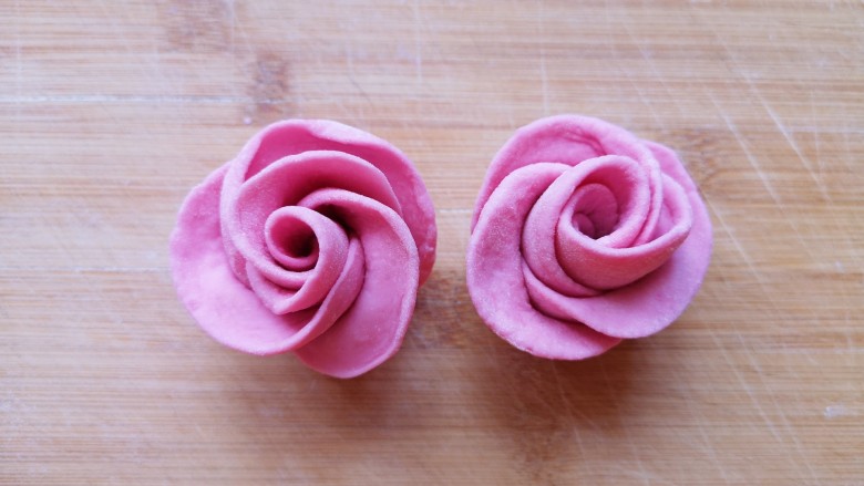 火龙果奶香馒头,切面朝下，整理一下玫瑰花的花瓣，漂亮的玫瑰花馒头就做好了，依次做好剩下的面团。