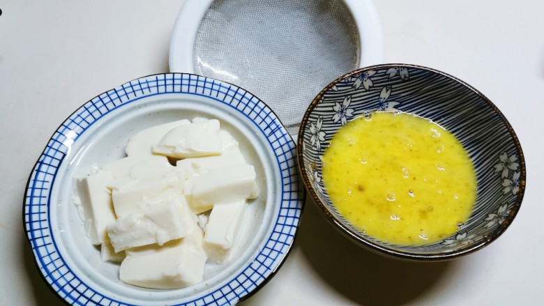 豆腐蒸蛋,用漏网 将鸡蛋液过滤倒入豆腐碗里