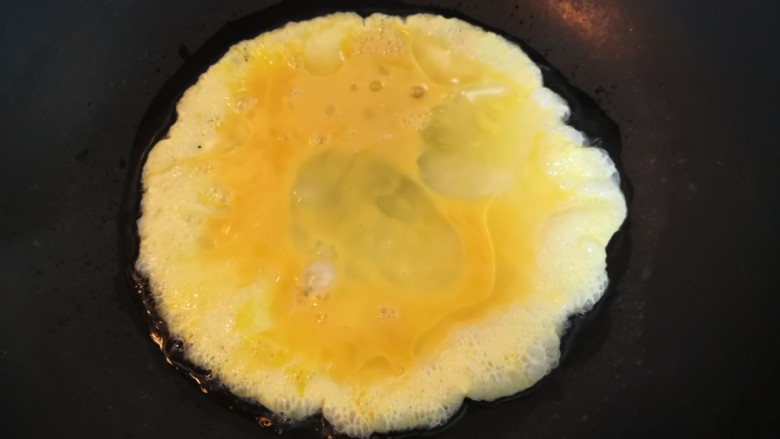韭菜锅贴,倒入鸡蛋液，煎至鸡蛋，底部凝固