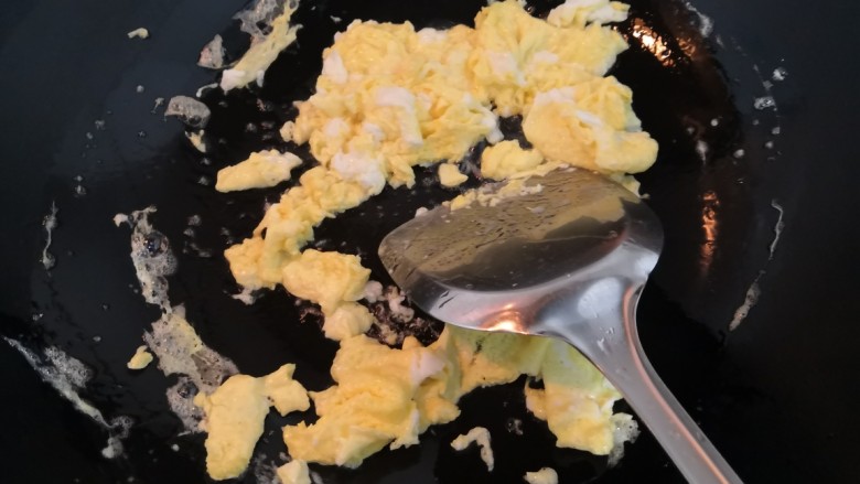 韭菜锅贴,鸡蛋底部凝固后，快速的翻炒，使鸡蛋成型，炒碎，然后关火