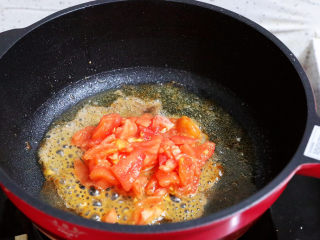 番茄虾仁培根蛋炒饭,锅中倒入适量的食用油烧热，放入番茄翻炒至出汁