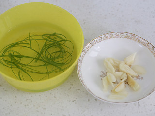 家常烧豆腐,小葱取绿色部分，切成丝泡水里，蒜头拍碎；