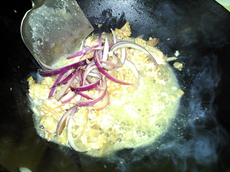 葱爆鱿鱼,翻炒至汤汁减少，放入炒好的洋葱，翻炒均匀。