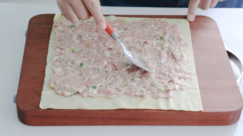 千张包肉,将搅拌好的肉馅均匀的涂抹到豆皮上