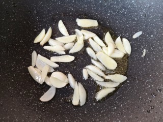 干煸豇豆,锅底留余油，下入蒜片。