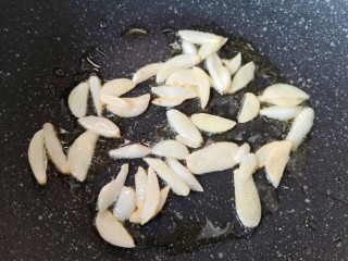 干煸豇豆,翻炒至蒜片表面微微变黄。
