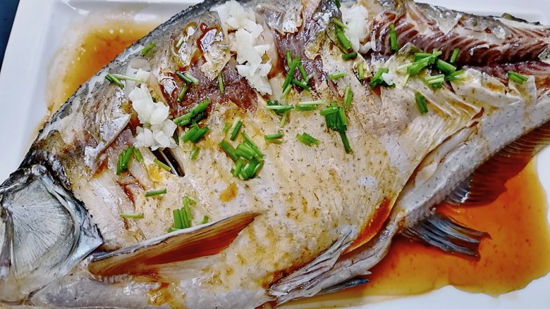 葱油鳊鱼,在鱼身上撒上葱花和蒜末