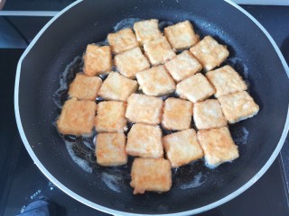 家常烧豆腐,锅里倒入适量的油，油热放入豆腐煎至两面金黄