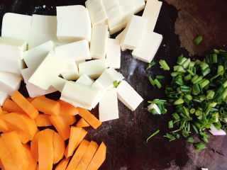 家常烧豆腐,胡萝卜削皮后切块，小葱切末