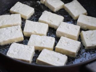 家常烧豆腐,4.锅中倒适量食用油烧至七八成热，将豆腐块排放锅中。