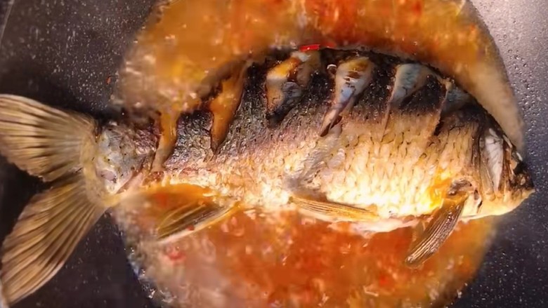 红烧草鱼,把鱼放入锅中。