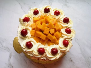 红丝绒水果裸蛋糕,放上最后一层蛋糕片，表面薄薄的抹上一层奶油，挤上一圈奶油花，放上樱桃装饰，中间位置放上大块的火龙果和芒果。