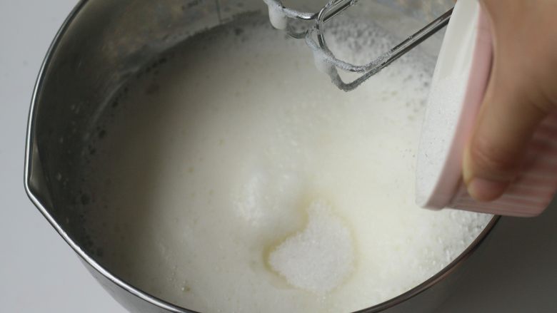 Kitty百香果轻乳酪蛋糕,蛋清用打蛋器打发至粗泡后分三次加入细砂糖