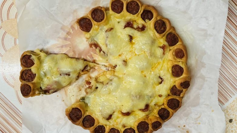 花边腊肠披萨,用剪刀剪一块。
