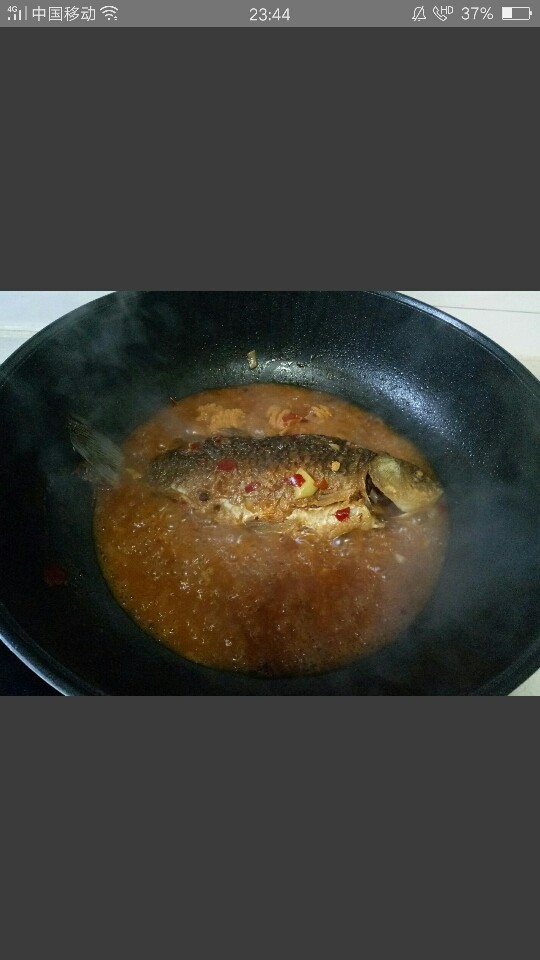 红烧草鱼,把鱼翻面在煮5分钟