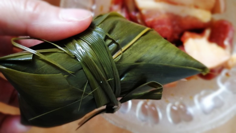 蜜枣白粽+彩豆肉粽,粽叶尾部包裹住开口处，虎口握紧，用马莲绑紧。