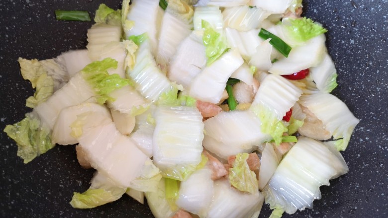 白菜炖豆腐,下入白菜帮翻炒至变软。