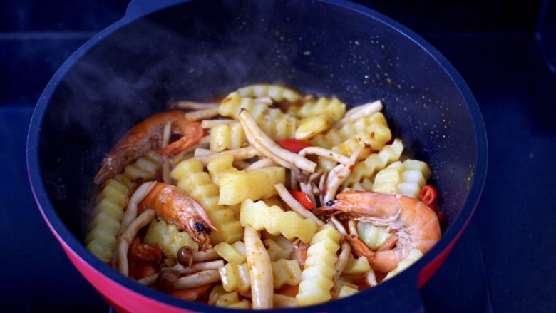 海鲜杂蔬麻辣香锅,加入焯过水的土豆条和蟹味菇，大火快速翻炒均匀。
