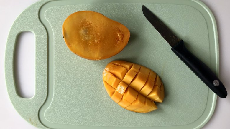 手抓饼变身小巧可爱的水果挞,把芒果切成小块。