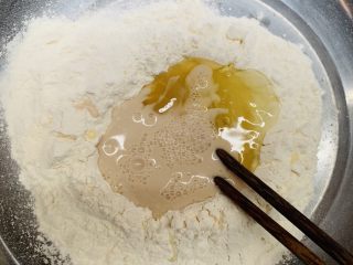 葡萄馅菠萝包,酵母加水搅拌均匀倒入面粉中。