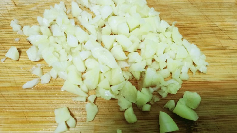 蒜香木耳菜,将蒜瓣用刀压扁再切碎