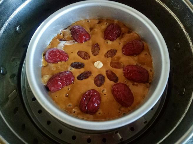 红糖红枣发糕,发酵好的面糊明显膨胀，加入红枣做装饰，还可以装饰些葡萄干或者干果。大火蒸20分钟后关火，焖3分钟后揭锅盖。