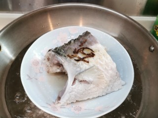 清蒸草鱼,鱼熟了，关火，拿出锅，把鱼汁水倒出不要。