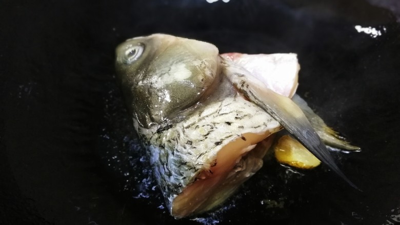鱼头豆腐汤,放入鱼头文火煎2分钟。