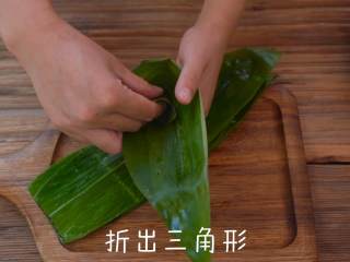 香甜的红糖蜜枣粽,从中间弯折成三角漏斗形。