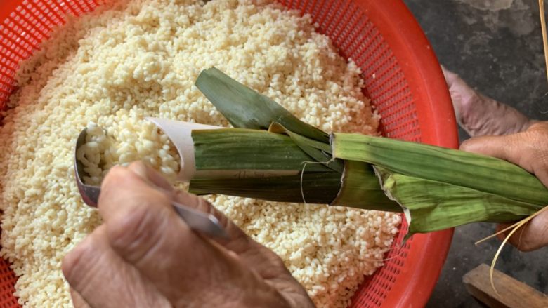水晶粽子,把米漏进筒子里，碱水粽主要就是包紧，所以一定要一勺勺慢慢来。