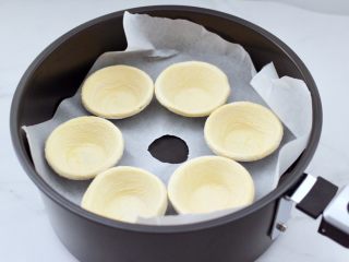快手奶酪酸奶樱桃蛋挞,把解冻的蛋挞皮码放在康佳空气炸锅中。