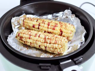 风味烤玉米,把炸篮放入炸锅里。