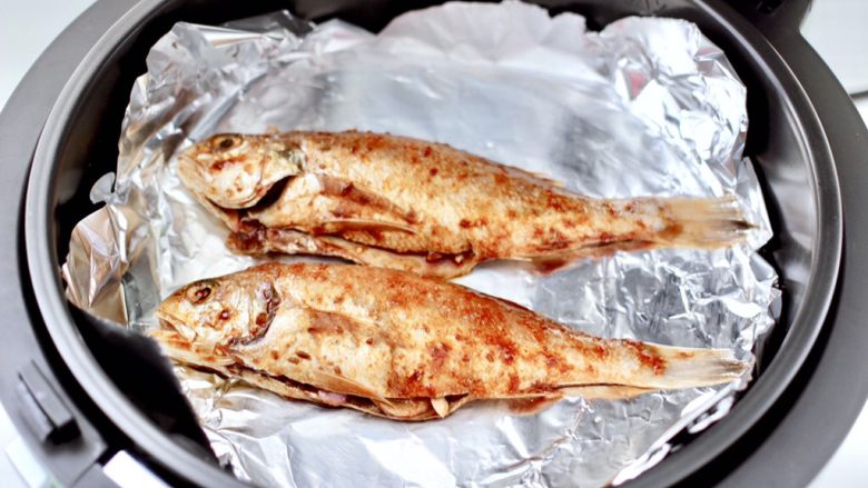 风味烧烤鱼,炸篮上铺上锡纸，放入腌制好的鱼。