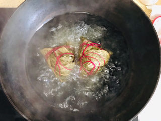美味的新疆酸奶粽子,开锅后，用筷子把粽子翻个身，使之彻底煮透