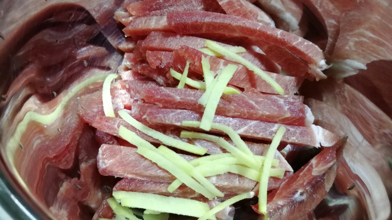 肉炒蒜苔,将肉条和姜丝放到盆里。