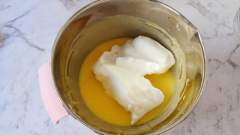 日式棉花蛋糕,将三分之一的蛋白倒入蛋黄中，翻拌均匀