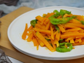 清炒南瓜丝,橙色的南瓜加上绿色的青椒丝，看起来是很赏心悦目。吃起来青椒丝脆口，南瓜丝软甜。非常好吃。你也可以试试哦。