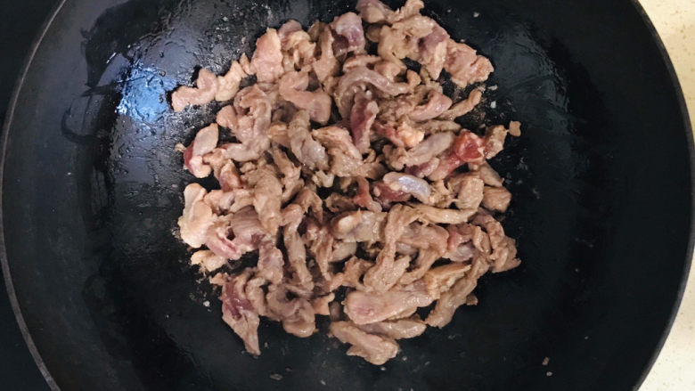 胡萝卜炒肉丝,一直翻炒至猪肉变色，为防止糊锅，要不停地翻炒