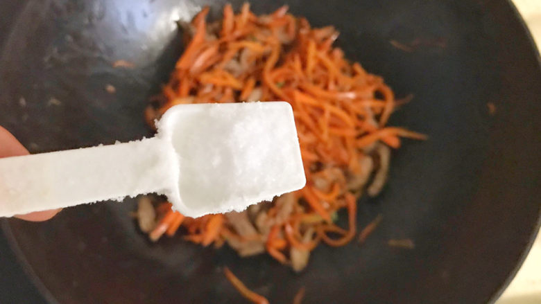 胡萝卜炒肉丝,撒上一勺盐调味