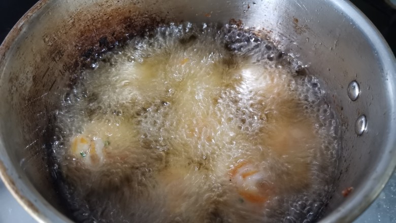 炸胡萝卜小丸子,四周冒起大泡就差不多的温度。所有做好的丸子，放进去炸至外表变硬，微黄。