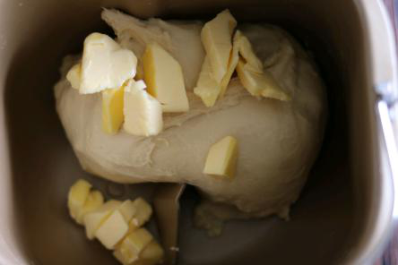 牛奶面包卷卷,揉至面团光滑，加入黄油，继续揉面。