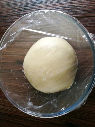 牛奶面包卷卷,滚圆，保鲜膜覆盖松弛15分钟。