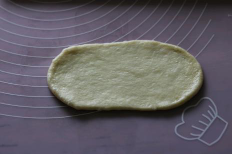 牛奶面包卷卷,取一个面团擀成椭圆形。