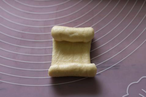 牛奶面包卷卷,用面杖擀成长舌形，上下往中间卷起。