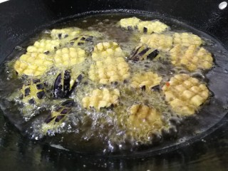 香酥炸茄花,花面炸至金黄色后翻过炸底部。