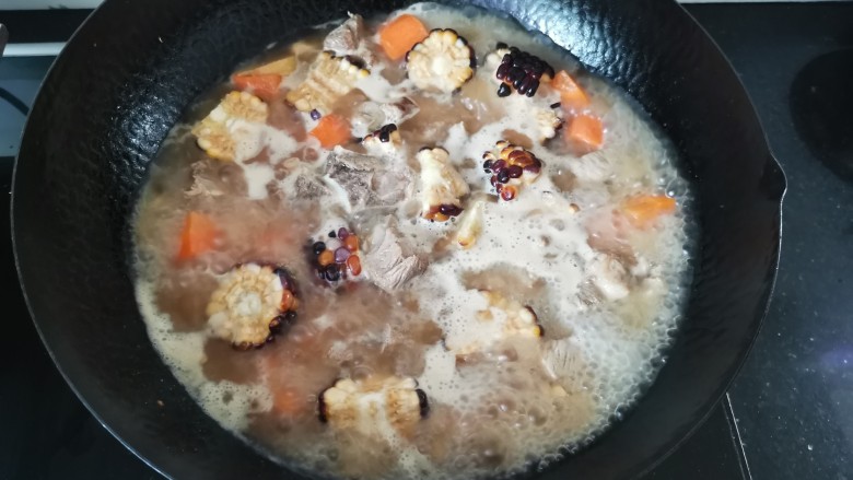 胡萝卜玉米排骨汤,倒入清水没过食材，除去浮沫