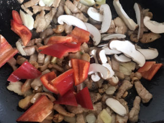 四季豆炒肉,然后倒入红辣椒和香菇翻炒均匀