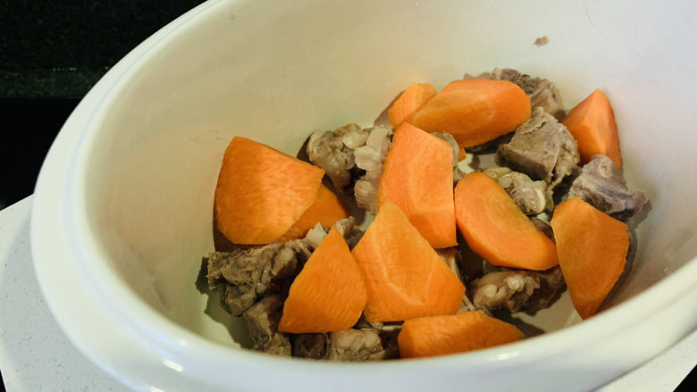 胡萝卜玉米排骨汤,炖锅内加入胡萝卜