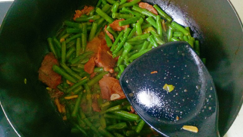 四季豆炒肉,盖上锅盖焖煮10分钟，加入一勺盐翻炒均匀即可