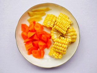 胡萝卜玉米排骨汤 ～,胡萝卜去皮洗净切滚刀块，玉米切断，姜切片，葱切末。